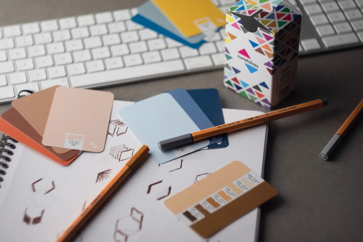 Brand colour swatches, pens and sketches on a designer’s desk