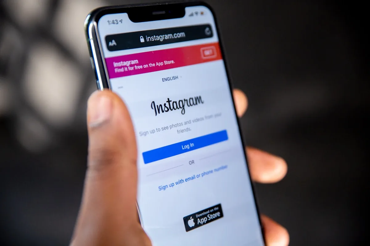 A hand holding a phone open on a social media app